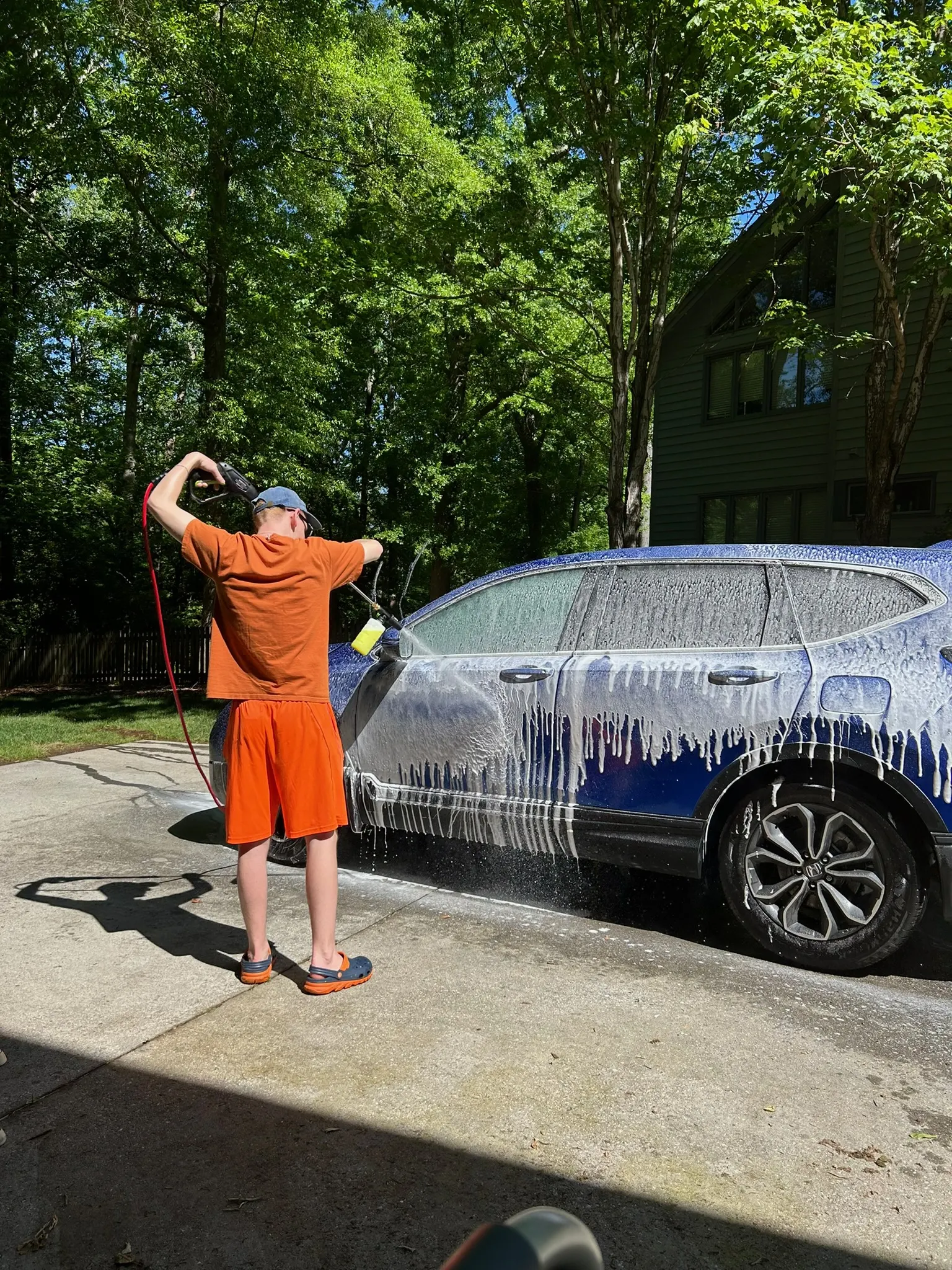 Alexander washing a blue SUV during an exterior detail
